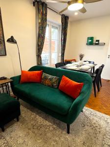 a living room with a green couch with orange pillows at Centro Coração in Tomar