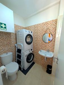a bathroom with a washing machine and a sink at Centro Coração in Tomar