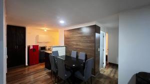 a dining room with a table and chairs and a kitchen at Escapadas Elqui Departamento en La Serena in La Serena