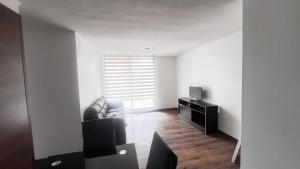 a living room with a couch and a television at Acogedor departamento en La Serena in La Serena