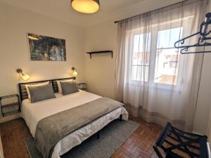 a bedroom with a large bed and a window at Centro Coração in Tomar