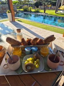 un vassoio di prodotti per la colazione su un tavolo accanto alla piscina di Ô nuits de saint cannat a Saint-Cannat