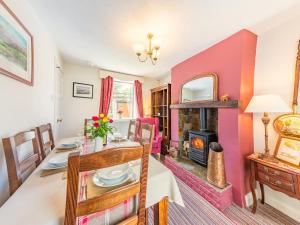 a dining room with a table and a fireplace at Pennine View in Long Marton