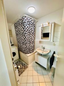 a bathroom with a sink and a shower curtain at Airport Apartments Rüsselsheim in Rüsselsheim