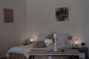 a living room with a bed and a table with flowers at Gites spa de charme L ETOILE SPA in Beynac-et-Cazenac +8 photos