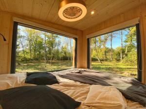 a large bed in a room with a large window at Homnest Morvand'Ailes - Cocon immersif en Morvan in Saulieu