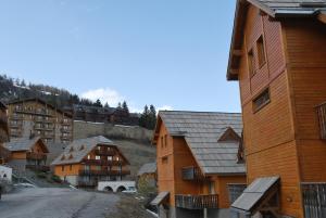 a group of wooden buildings in a mountain village at Chalets de Praroustan by Actisource in Pra-Loup