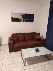 a brown couch in a living room with a coffee table at T2 5 Lys - centre ville, parking privé in Saint-Louis
