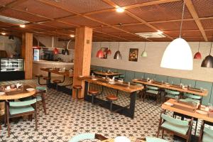 Un comedor con mesas y sillas de madera. en Hotel Shaktiheritage Inn, en Bhubaneshwar
