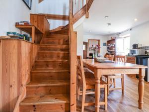 a wooden staircase in a kitchen with a wooden table at Wildflower Cottage in Lealholm