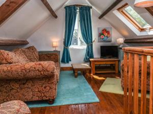 a living room with a couch and a tv at Wildflower Cottage in Lealholm
