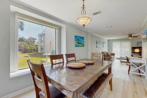 Un comedor con mesa y sillas y una ventana. en Gulf Winds #25, en Destin