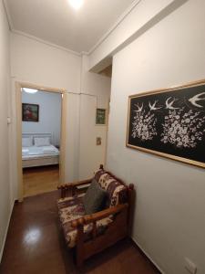 a living room with a couch and a painting on the wall at Hellen Guest House in Mesochórion