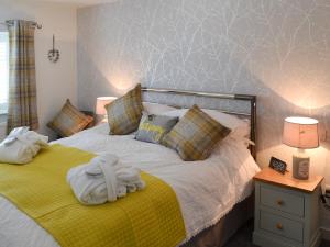 a bedroom with a bed with towels on it at Little Tregarthen in Padstow