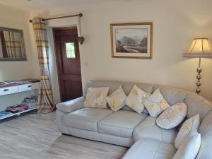 ein Wohnzimmer mit einem Sofa und Kissen in der Unterkunft Railway Cottage in Brassington