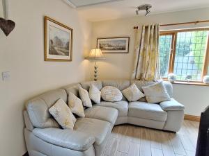 ein Wohnzimmer mit einem Sofa mit Kissen in der Unterkunft Railway Cottage in Brassington
