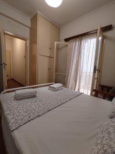 a bedroom with a bed with two towels on it at Hellen Guest House in Mesochórion