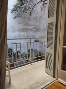 an open door to a balcony with a view of the ocean at Hellen Guest House in Mesochórion