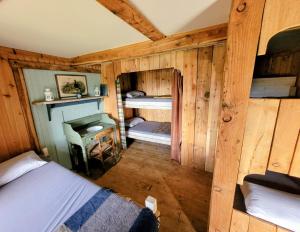 a room with two beds in a wooden cabin at Cragaig Bothy in Geasgill Mòr
