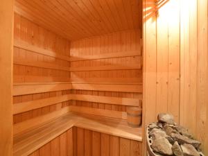 a wooden sauna with a trash can in it at Rendeux Retreat with Sauna in La Roche-en-Ardenne