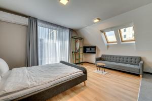 a bedroom with a bed and a couch at La Shara Building in Sofia