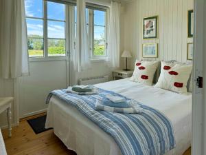 ein Schlafzimmer mit einem großen weißen Bett und Kissen in der Unterkunft Cottage With Views Over Nature Reserve In Arild in Arild