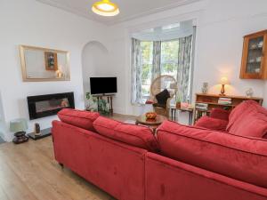 a living room with a red couch and a fireplace at The Ives in Skipton