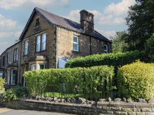 an old brick house with bushes in front of it at The Ives in Skipton