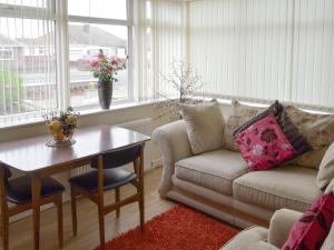 a living room with a couch and a table at Rossall Beach Cottage in Cleveleys