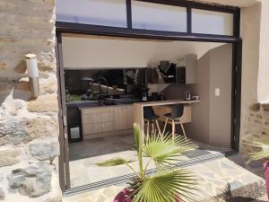 a kitchen with a large sliding glass door at Gite Sublime Spa, Piscine Indoor in Mostuéjouls