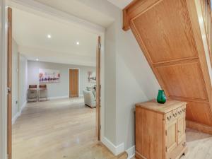 a living room with a staircase and a hallway with a kitchen at Clarion Lodge Cottage Ilkley in Menston +31 photos