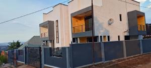 a house with a blue fence in front of it at Diaspora House in Kigali