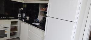 a kitchen with a white refrigerator and black tiles at Diaspora House in Kigali