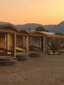 a house in the desert with a sunset in the background at Heaven Dune Camp in Nuweiba