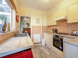 a kitchen with wooden counters and a counter top at Trafalgar House in Gorleston-on-Sea