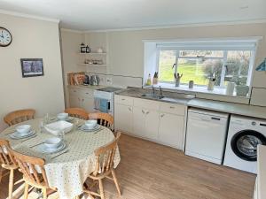 a kitchen and dining room with a table and chairs at Bridge Park in Killin