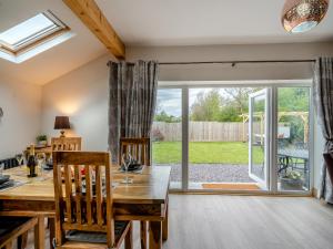 a dining room with a table and a large sliding glass door at Briar Cottage in Great Eccleston
