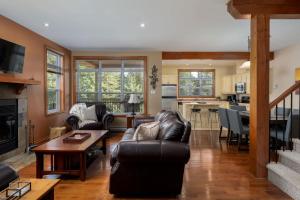a living room with a couch and a table at L'Aiglon - Nature Golf and Relaxation in Mont-Tremblant in Mont-Tremblant +40 photos