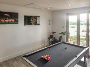 a room with a pool table with balls on it at Wysteria, North Lodge in Rusper