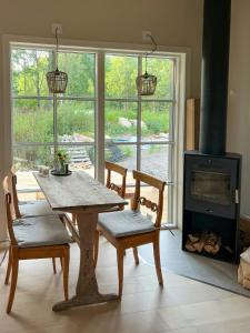 a living room with a table and chairs and a fireplace at Modern Cabin In The Heart Of Småland in Tolg
