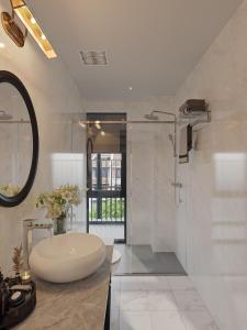 a white bathroom with a tub and a sink at Luna Oriental in Phu Quoc