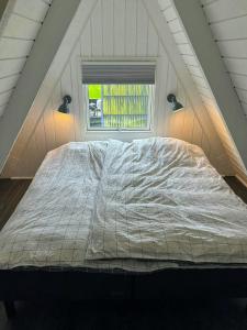 un grand lit dans une chambre avec une fenêtre dans l'établissement Holiday Home At Himmerland Golf & Spa Resort, à Gatten