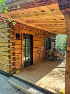 EjstrupにあるAuthentic Log Cabin In Forest Near Ejstrupholmのドア付きの木製デッキを備えた木造キャビン +7枚の写真