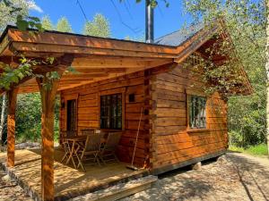EjstrupにあるAuthentic Log Cabin In Forest Near Ejstrupholmのポーチとパティオ付きのログキャビン