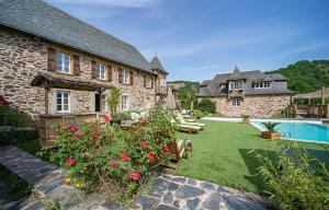 MonteilsにあるCharming House Overlooking Aveyron Valleyの庭とプールのある大きな石造りの家