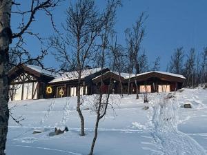 ein Haus im Schnee davor in der Unterkunft Log Cabin With Panoramic Views Of Hallingskarvet in Hovet + 13 Fotos
