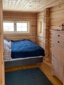 ein kleines Schlafzimmer mit einem Bett in einer Blockhütte in der Unterkunft Log Cabin With Panoramic Views Of Hallingskarvet in Hovet