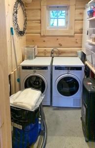 eine Waschküche mit zwei Waschmaschinen und einem Fenster in der Unterkunft Log Cabin With Panoramic Views Of Hallingskarvet in Hovet