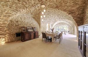 a dining room with a table and a stone wall at Historic Mansion In Provence Vineyards in La Tour-dʼAigues