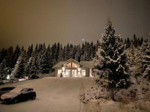 a house with a christmas tree in the snow at Family Cabin With Views In Lygnalia in Jaren